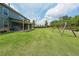 Expansive backyard featuring a covered patio, a swing set and lush green grass at 5789 Creek Indian Dr, Sugar Hill, GA 30518