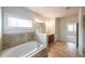 Primary bathroom features a soaking tub, tiled floors, and a glass shower at 5789 Creek Indian Dr, Sugar Hill, GA 30518