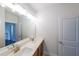 Bathroom featuring a double vanity with sinks, a large mirror, and modern lighting fixtures at 5789 Creek Indian Dr, Sugar Hill, GA 30518