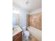 Bright bathroom featuring tiled walls, a vanity with sink, toilet and a bathtub with shower at 5789 Creek Indian Dr, Sugar Hill, GA 30518