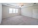 Generous bedroom with a ceiling fan, tray ceiling, a large window, and plush carpet at 5789 Creek Indian Dr, Sugar Hill, GA 30518