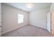 A clean, carpeted bedroom with a window and a closet door, offering a cozy and functional space at 5789 Creek Indian Dr, Sugar Hill, GA 30518
