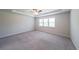 Expansive bedroom with tray ceilings, plush carpet, and natural light from large windows at 5789 Creek Indian Dr, Sugar Hill, GA 30518