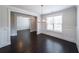 Bright dining room featuring dark hardwood floors, wainscotting, and a modern chandelier at 5789 Creek Indian Dr, Sugar Hill, GA 30518
