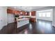 Open kitchen with stainless steel appliances, granite countertops, and dark wood floors at 5789 Creek Indian Dr, Sugar Hill, GA 30518