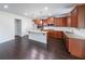 Spacious kitchen with dark wood floors, wooden cabinets, granite countertops, and a center island at 5789 Creek Indian Dr, Sugar Hill, GA 30518