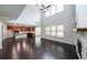 Open-concept living room with vaulted ceiling, fireplace, and hardwood floors at 5789 Creek Indian Dr, Sugar Hill, GA 30518