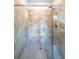 Tile shower with glass door, bench, shower head, and neutral tile design at 5789 Creek Indian Dr, Sugar Hill, GA 30518