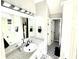 A luxurious bathroom with granite countertops, black and white tiled floors, and updated light fixtures at 96 Wildwood Dr, Temple, GA 30179