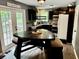 Eat-in kitchen featuring stainless steel appliances, dark cabinets, granite counters, and a unique triangular dining table with bench seating at 96 Wildwood Dr, Temple, GA 30179