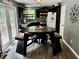 Eat-in kitchen featuring stainless steel appliances, dark cabinets, granite counters, and a unique triangular dining table with bench seating at 96 Wildwood Dr, Temple, GA 30179