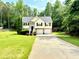 Charming two-story home with a well-manicured lawn, two-car garage, and inviting front entrance surrounded by lush greenery at 96 Wildwood Dr, Temple, GA 30179