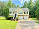 Charming two-story home with a well-manicured lawn, two-car garage, and inviting front entrance surrounded by lush greenery at 96 Wildwood Dr, Temple, GA 30179