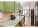 This kitchen features green cabinets and granite countertops, a well-equipped area for cooking and dining at 1195 Milton Se Ter # 2203, Atlanta, GA 30315