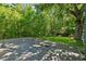 Backyard patio area surrounded by lush greenery and mature trees at 13795 Arnold Mill Rd, Roswell, GA 30075