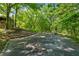 Stone backyard patio with stairs leading up to a house surrounded by lush trees at 13795 Arnold Mill Rd, Roswell, GA 30075