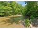Scenic creek view with clear water flowing through a lush green, wooded landscape at 13795 Arnold Mill Rd, Roswell, GA 30075