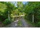 Gated entrance and driveway, ensuring privacy, surrounded by lush trees and foliage at 13795 Arnold Mill Rd, Roswell, GA 30075