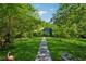 Charming home with a stone walkway leading to a lush, green front yard surrounded by trees at 13795 Arnold Mill Rd, Roswell, GA 30075