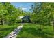 Quaint blue house with a stone walkway surrounded by mature trees and a green lawn at 13795 Arnold Mill Rd, Roswell, GA 30075