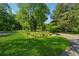 Landscaped front yard featuring a lush green lawn and mature trees that provide shade at 13795 Arnold Mill Rd, Roswell, GA 30075