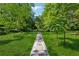 Expansive front yard with stone pathway through the lush lawn and mature trees at 13795 Arnold Mill Rd, Roswell, GA 30075