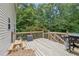 A spacious back deck with wood railing offers an outdoor space perfect for grilling and entertaining with a wooded view at 25 Grange Ct, Sharpsburg, GA 30277