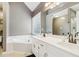 Bright bathroom features a large tub, double sink vanity with granite counters, and a walk-in shower at 25 Grange Ct, Sharpsburg, GA 30277