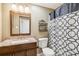 Bathroom with granite countertop, dark wood vanity, and patterned shower curtain at 25 Grange Ct, Sharpsburg, GA 30277