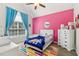 Bright bedroom boasts a vaulted ceiling, pink accent wall, and playful decor at 25 Grange Ct, Sharpsburg, GA 30277