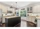 Spacious eat-in kitchen with granite counters, stainless steel appliances, a black island, and dark hardwood floors at 25 Grange Ct, Sharpsburg, GA 30277