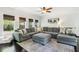 Bright living room featuring a large gray sectional sofa, dark hardwood floors, and a ceiling fan at 25 Grange Ct, Sharpsburg, GA 30277