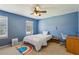 Bright bedroom with blue walls, ceiling fan, large window, and rainbow rug accent at 3145 Indian Hills Ne Dr, Marietta, GA 30068