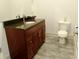 Charming powder room featuring a stylish vanity with granite countertop and elegant fixtures at 4590 River Stone Trl, Douglasville, GA 30135
