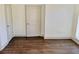 Bedroom features dark wood flooring and neutral walls with white trim, door and window at 4590 River Stone Trl, Douglasville, GA 30135