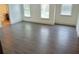 Bright bedroom with three windows offering ample natural light and sleek wood-look flooring at 4590 River Stone Trl, Douglasville, GA 30135