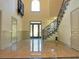 Grand two-story foyer with beautiful tile flooring, iron-work staircase, and transom window above the door at 4590 River Stone Trl, Douglasville, GA 30135