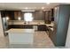 Modern kitchen with stainless steel appliances, dark cabinetry, island, and tiled floor at 4590 River Stone Trl, Douglasville, GA 30135