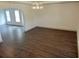 Living room with tray ceilings, chandelier, neutral paint and hardwood floors at 4590 River Stone Trl, Douglasville, GA 30135