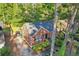 Aerial view of brick home with well-kept lawn, driveway, mature trees, and verdant surroundings at 1521 Deerwood Dr, Decatur, GA 30030