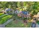 Aerial view of a charming brick home featuring a lush front yard, mature trees, and a private driveway at 1521 Deerwood Dr, Decatur, GA 30030