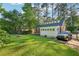 Manicured backyard features lush lawn, mature trees, and a driveway for off-street parking at 1521 Deerwood Dr, Decatur, GA 30030