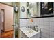 Cozy bathroom featuring white tiled walls, and a sink with a mirror and vanity at 1521 Deerwood Dr, Decatur, GA 30030