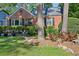 Charming brick home featuring a well-manicured front yard with mature trees and lush landscaping at 1521 Deerwood Dr, Decatur, GA 30030