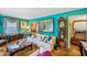 Bright living room with unique turquoise walls, vintage furnishings, and natural light from the window at 1521 Deerwood Dr, Decatur, GA 30030