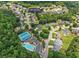 Aerial view of community featuring a community pool, tennis courts, and tree-lined streets surrounding single-Gathering homes at 1850 Overlook Springs Ln, Cumming, GA 30040