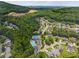 Scenic aerial view of a community featuring lush tree coverage and the pool and tennis court amenity area at 1850 Overlook Springs Ln, Cumming, GA 30040