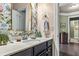 Stylish bathroom with floral wallpaper, modern vanity, and gold trimmed mirror at 1850 Overlook Springs Ln, Cumming, GA 30040