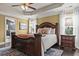 Bedroom with tray ceilings, a decorative ceiling fan, and a large bed frame with a plush comforter at 1850 Overlook Springs Ln, Cumming, GA 30040