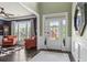 Inviting foyer with hardwood floors, decorative mirror, and a view into a living room with large window at 1850 Overlook Springs Ln, Cumming, GA 30040